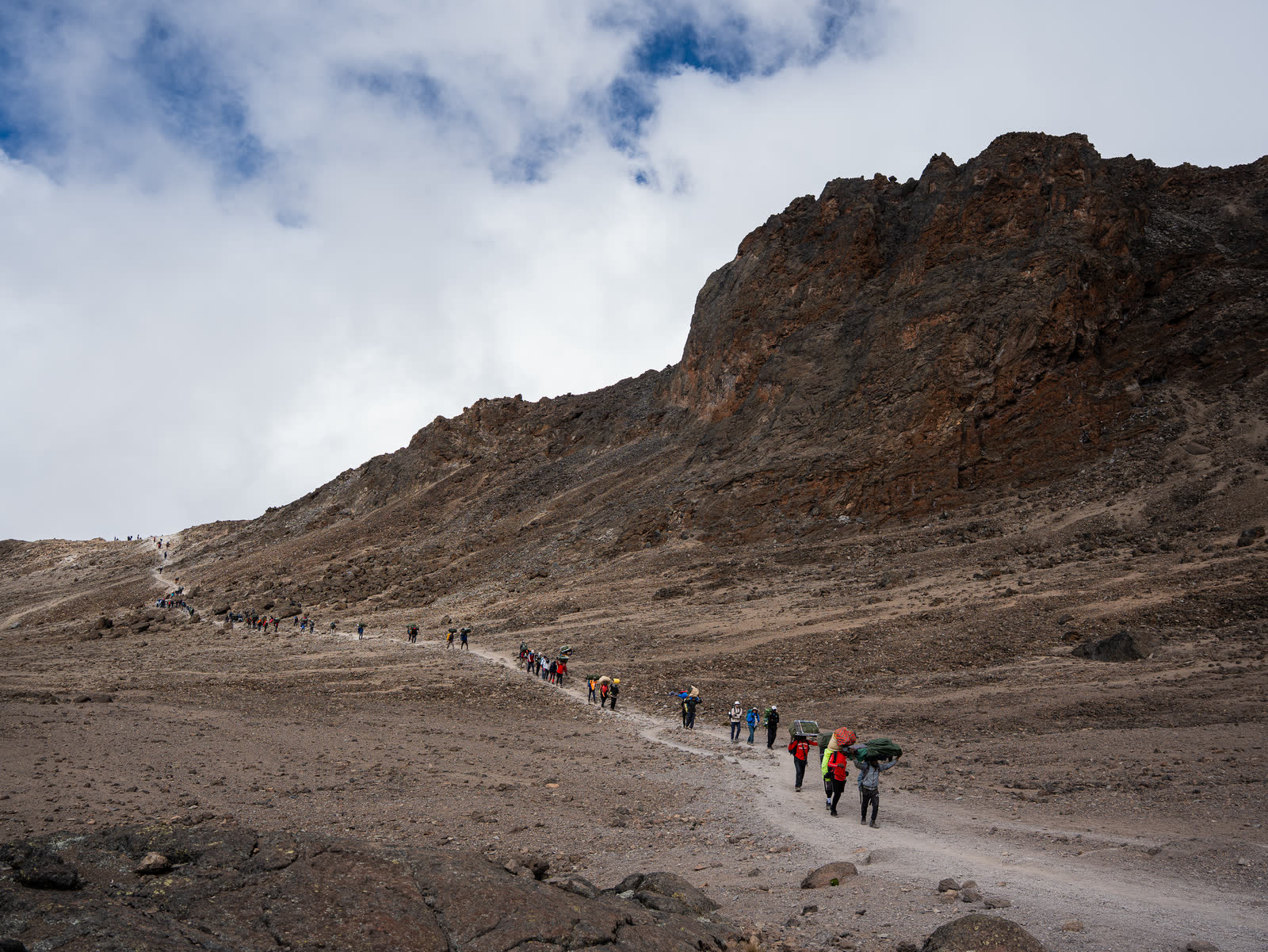 Trekkers crossing a high Kilimanjaro ridge.