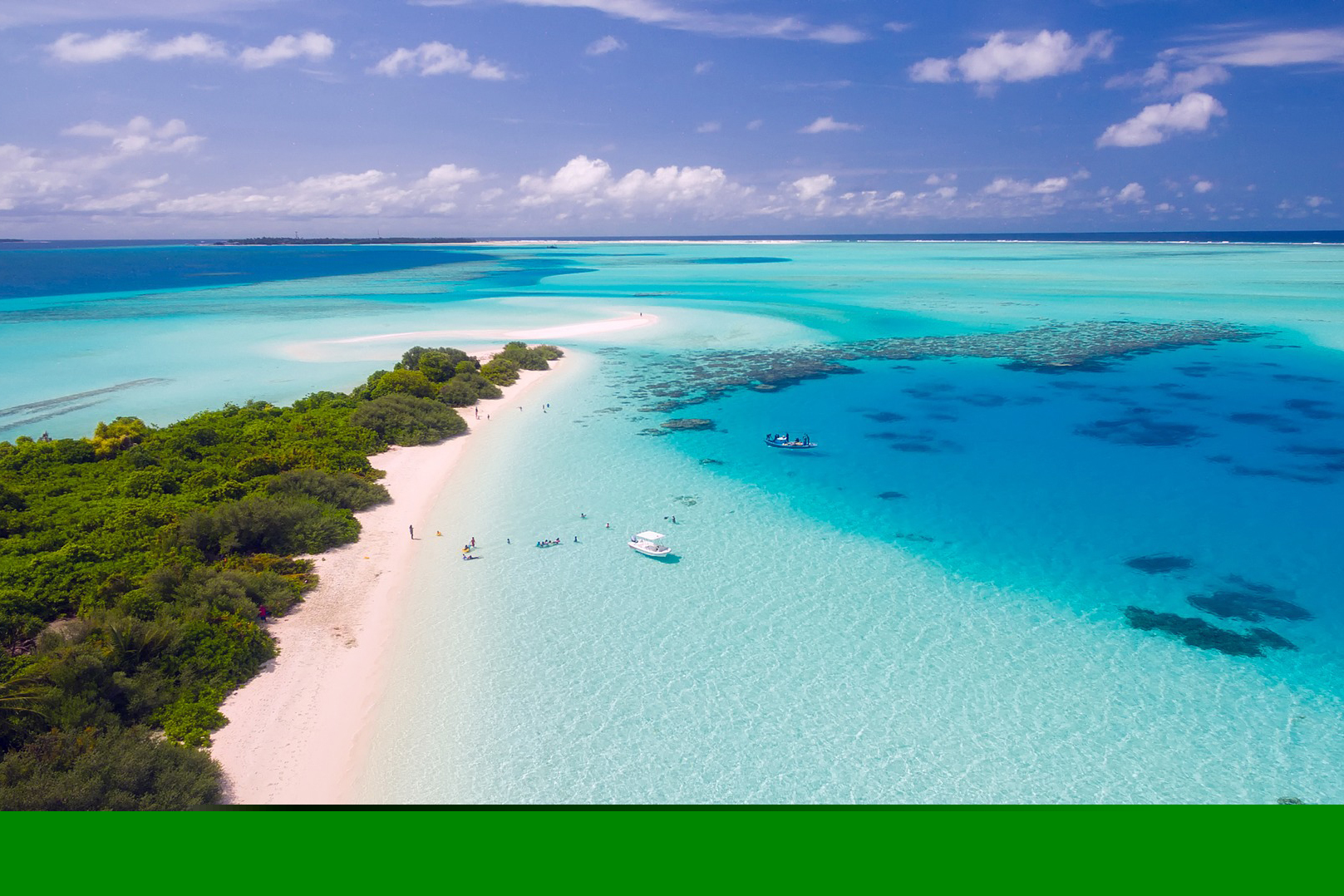 Aerial view of a turquoise lagoon, sandy beach and island coastline.