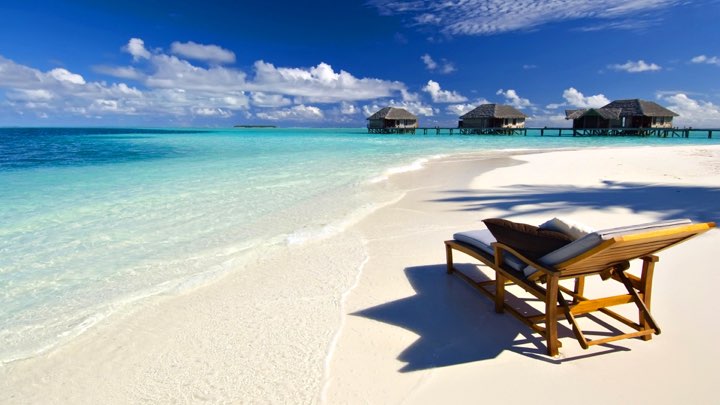 White-sand beach and overwater bungalows on a Zanzibar coast stay.